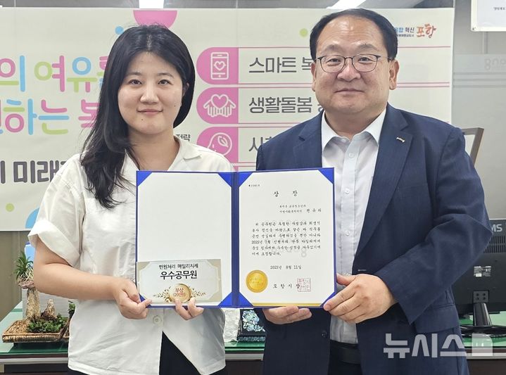 [포항=뉴시스] 송종욱 기자 = 포항시는 7월 '민원 처리 단축 마일리지' 우수 공무원에 편유리 주무관을 선정해 시상했다. 사진은 지난 11일 편준 시 복지국장(오른쪽)이 편 주무관에게 상을 준 후 격려하는 모습. (사진=포항시 제공) 2025.08.12. photo@newsis.com