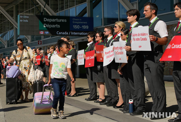 [밴쿠버=신화/뉴시스] 11일(현지 시간) 캐나다 브리티시컬럼비아주 리치먼드 밴쿠버 국제공항에서 에어캐나다 승무원들이 전국 행동의 날을 맞아 침묵시위를 하고 있다. 이들은 근무 환경 개선과 임금 인상 등을 요구하고 있다. 2025.08.12.
