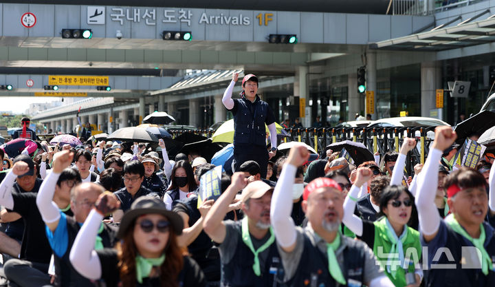 [서울=뉴시스] 김선웅 기자 = 전국공항노동자연대(공공운수노조 인천공항지역지부, 전국공항노동조합)가 12일 서울 강서구 김포국제공항에서 투쟁선포 결의대회를 열고 2025 단체교섭 전개, 즉각적인 교대제 개편 및 인력충원, 낙찰률 100% 적용, 결원정산 폐지 등을 촉구하고 있다. 2025.08.12. mangusta@newsis.com