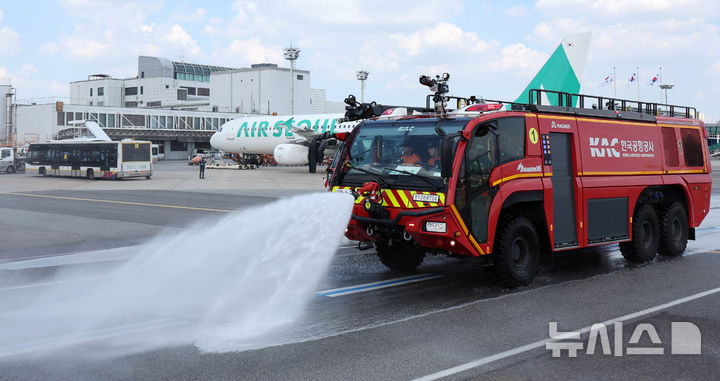 [서울=뉴시스] 김선웅 기자 = 12일 서울 강서구 김포국제공항 국내선 이동지역에서 한국공항공사 관계자들이 소방차를 이용해 폭염 대비 계류장 살수작업을 하고 있다. 살수작업은 활주로 등 이동지역 포장면의 표면온도가 60도 이상일 경우 물을 살포해 온도를 약 10도 가량 낮추어 포장 손상 위험을 줄이고 항공기 운항 안전성을 높이는 효과가 있다. 한국공항공사는 폭염경보가 발령될 경우 항공기 이동지역 포장면의 온도를 하루 세 차례 측정해 살수작업 여부를 결정한다. (공동취재) 2025.08.12. photo@newsis.com