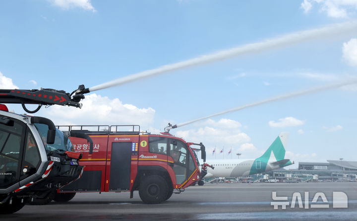 [서울=뉴시스] 김선웅 기자 = 12일 서울 강서구 김포국제공항 국내선 이동지역에서 한국공항공사 관계자들이 소방차를 이용해 폭염 대비 계류장 살수작업을 하고 있다. 살수작업은 활주로 등 이동지역 포장면의 표면온도가 60도 이상일 경우 물을 살포해 온도를 약 10도 가량 낮추어 포장 손상 위험을 줄이고 항공기 운항 안전성을 높이는 효과가 있다. 한국공항공사는 폭염경보가 발령될 경우 항공기 이동지역 포장면의 온도를 하루 세 차례 측정해 살수작업 여부를 결정한다. (공동취재) 2025.08.12. photo@newsis.com