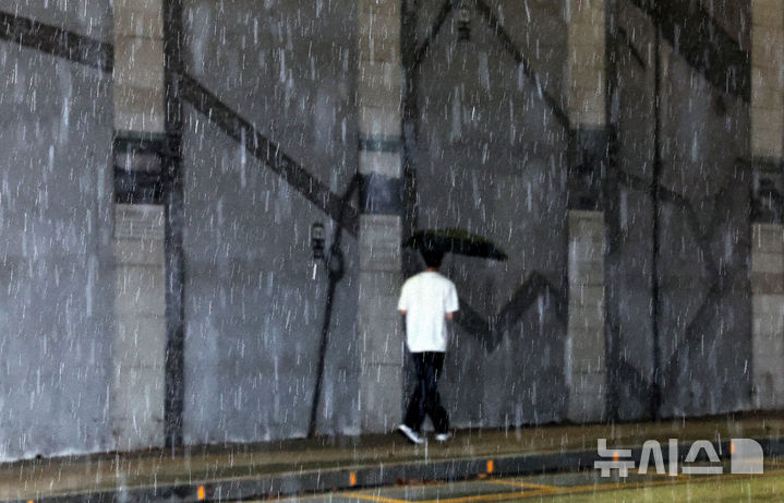 [대구=뉴시스] 이무열 기자 = 비가 내리는 12일 대구 동구 동촌유원지 인근에서 한 시민이 우산을 쓰고 이동하고 있다. 2025.08.12. lmy@newsis.com