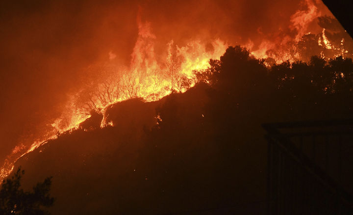 [파트라=AP/뉴시스] 12일(현지 시간) 그리스 서부 파트라 인근 카미니아 마을 나무들이 산불에 휩싸여 있다. 2025.08.13.