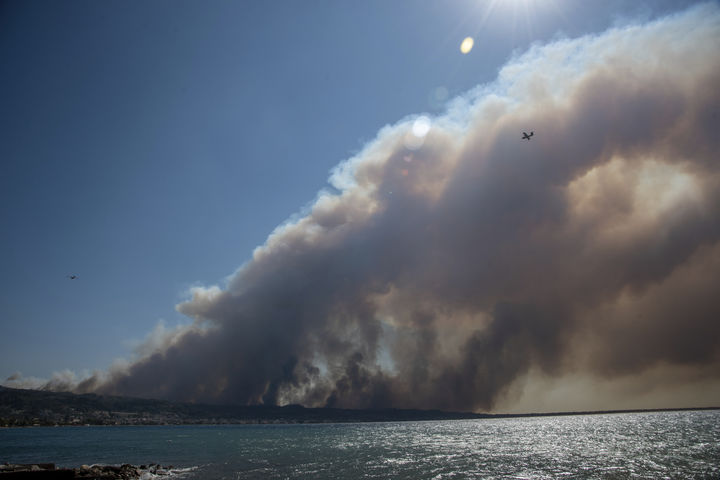 [파트라=AP/뉴시스] 12일(현지 시간) 그리스 서부 파트라 인근 카토 아하이아 마을 상공에 산불 연기가 뒤덮인 가운데 소방 항공기 한 대가 비행하고 있다. 2025.08.13.