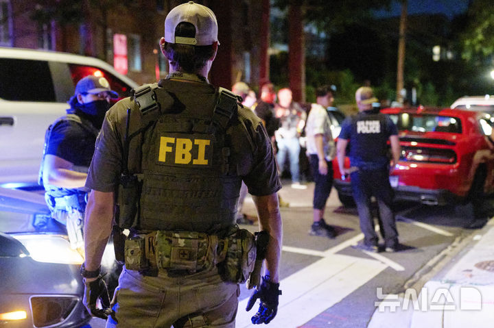 [AP/뉴시스] 12일 밤 미 수도 워싱턴 거리에서 연방 정부의 BATFE(주류 담배 총기 폭발물 단속국), FBI, 국립공원 경찰국 소속 요원들이 한 커플에게 뭔가 묻고 있다 