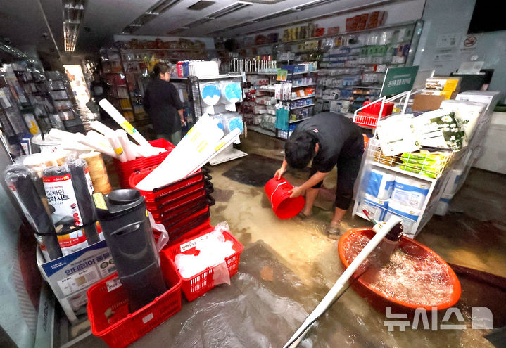 [인천=뉴시스] 전진환 기자 = 13일 오전 간밤에 내린 폭우에 침수된 인천 서구 정서진 중앙시장 한 상가에서 상인이 배수 작업을 하고 있다. 2025.08.13. amin2@newsis.com