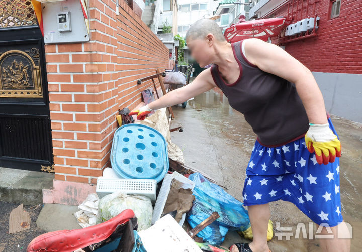 [인천=뉴시스] 전진환 기자 = 간밤에 내린 폭우로 인천 서구 석남동 저지대 주택가가 침수된 가운데 13일 오전 물이 빠진 후 한 입주민이 물이 차올랐던 높이를 가리키고 있다. 2025.08.13. amin2@newsis.com