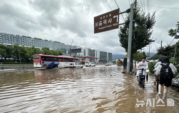 [고양=뉴시스] 홍효식 기자 = 서울을 비롯한 수도권에 호우주의보가 내린 13일 경기 고양시 통일로에서 시민들이 침수된 거리를 걷고 있다. 2025.08.13. yesphoto@newsis.com
