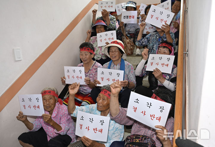 [광주=뉴시스] 박기웅 기자 = 13일 오후 광주 광산구 삼도동 행정복지센터 2층에 마련된 '광주시 자원회수시설(쓰레기 소각장) 설치사업 전략·기후환경평가 초안 주민설명회' 공청회장 입구를 삼도동 주민들이 점거, 공청회 개최를 반대하는 구호를 외치고 있다. 2025.08.13. pboxer@newsis.com