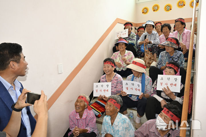 [광주=뉴시스] 박기웅 기자 = 13일 오후 광주 광산구 삼도동 행정복지센터 2층에 마련된 '광주시 자원회수시설(쓰레기 소각장) 설치사업 전략·기후환경평가 초안 주민설명회' 공청회장 입구를 삼도동 주민들이 점거, 공청회 개최를 반대하는 구호를 외치고 있다. 2025.08.13. pboxer@newsis.com