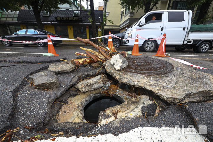 [서울=뉴시스] 황준선 기자 = 서울에 많은 비가 내린 13일 서울 종로구 한 도로가 파손돼 주변이 통제되고 있다. 2025.08.13. hwang@newsis.com