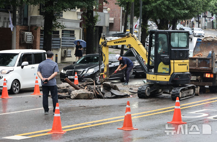 [서울=뉴시스] 황준선 기자 = 서울에 많은 비가 내린 13일 서울 종로구 한 도로가 파손돼 구청 관계자들이 복구작업을 하고 있다. 2025.08.13. hwang@newsis.com