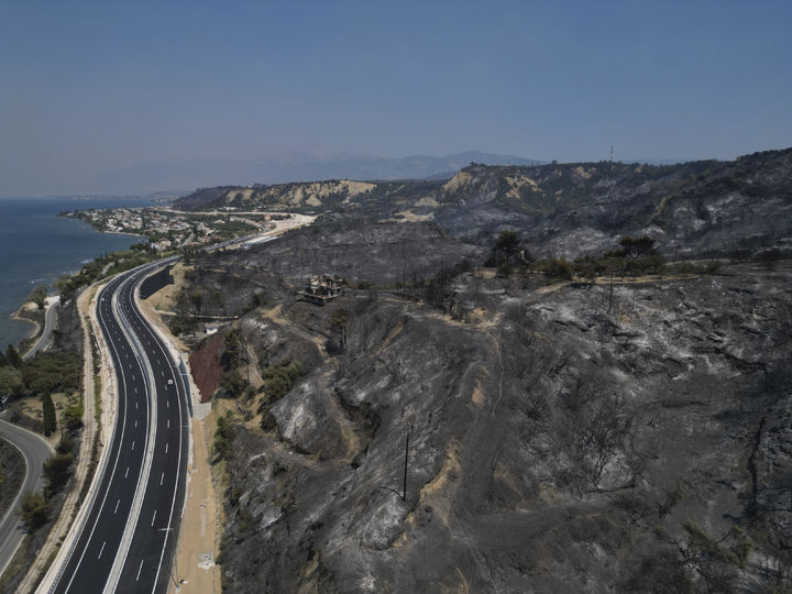 [파트라스=AP/뉴시스] 13일(현지 시간) 그리스 서부 파트라스에서 산불이 발생해 카미니아 해변 마을 인근이 불에 타 검게 그을려 있다. 2025.08.14.