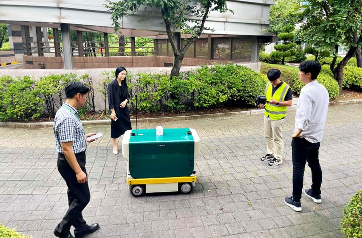 [수원=뉴시스] 경기 수원시 관계자들이 광교지역 아파트단지에서 자율주행 로봇 '로바'의 방범 기능을 점검하고 있다. 로봇은 지능형 폐쇄회로(CC)TV를 탑재해 위험 상황을 실시간으로 감지한다. (사진=수원시 제공) 2025.08.14. photo@newsis.com *재판매 및 DB 금지
