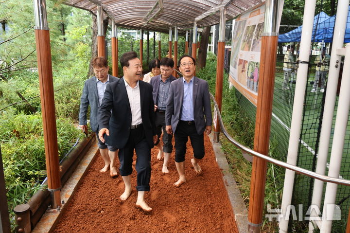 [의왕=뉴시스] 김성제 시장이 개장한 황톳길을 시민들과 걷고 있다. (사진=의왕시 제공).2025.08.14. photo@newsis.com *재판매 및 DB 금지