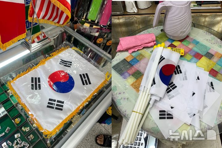 [서울=뉴시스]유서영 인턴기자=서울 남대문 시장에서 판매 중인 태극기들. 국산 태극기(왼쪽)는 유광 원단에 금색 수술이 덧대어진 형태로, 색상이 선명하고 마감 처리도 정교하다. 같은 시장에서 판매되는 중국산 태극기(오른쪽)은 올이 나간 흔적이 쉽게 발견되고 원단과 인쇄 품질도 비교적 떨어진다. 2025.08.14
