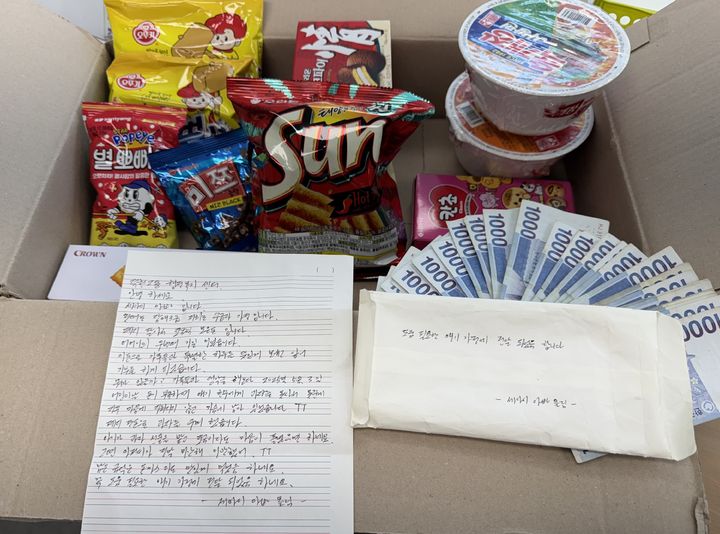 [부산=뉴시스] 지난 13일 '세아이 아빠'라고 밝힌 기부가자 덕천지구대 앞에 조용히 놓고 간 상자. 안에는 1000원권 지폐 30장(3만원)과 뿌셔뿌셔·초코파이·컵라면 등 간식 꾸러미, 손편지가 함께 들어 있었다. (사진=북구 제공) 2025.08.15. photo@newsis.com *재판매 및 DB 금지