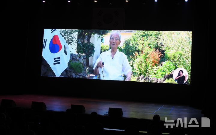 [제주=뉴시스] 오영재 기자 = 15일 오전 제주시 제주아트센터에서 열린 제80주년 제주 광복절 경축식에서 참석자들이 제주 유일 생존 독립유공자 강태선(101) 애국지사의 애국가 제창 영상을 관람하고 있다. 2025.08.15. oyj4343@newsis.com