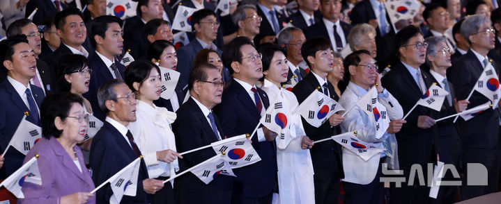 [서울=뉴시스] 최동준 기자 = 이재명 대통령과 김혜경 여사가 15일 서울 종로구 세종문화회관에서 열린 제80주년 광복절 경축식에서 참석자들과 광복절 노래를 제창하며 태극기를 흔들고 있다. 2025.08.15. photocdj@newsis.com