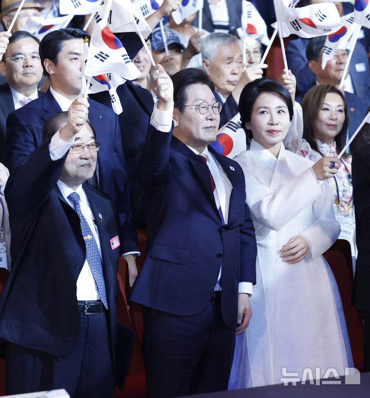 [서울=뉴시스] 최동준 기자 = 이재명 대통령과 김혜경 여사가 15일 서울 종로구 세종문화회관에서 열린 제80주년 광복절 경축식에서 참석자들과 태극기를 흔들고 있다. 왼쪽은 이종찬 광복회장. 2025.08.15. photocdj@newsis.com