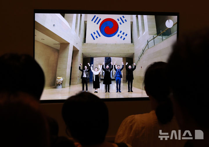 [서울=뉴시스] 이영환 기자 = 광복절인 15일 오후 서울 용산구 국립중앙박물관을 찾은 관람객들이 전시 영상을 살펴보고 있다.  국내에 남아 있는 태극기 중 가장 오래된 데니 태극기는 고종이 외교고문이었던 미국인 데니에게 하사한 태극기다. 2025.08.15. 20hwan@newsis.com