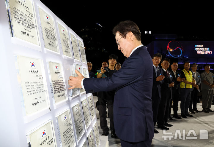 [서울=뉴시스] 고범준 기자 = 이재명 대통령이 15일 서울 세종대로 광화문광장에서 열린 제21대 대통령 국민임명식 '광복 80년, 국민주권으로 미래를 세우다' 행사에서 마지막 임명장을 받은 뒤 거치하고 있다. 2025.08.15. bjko@newsis.com