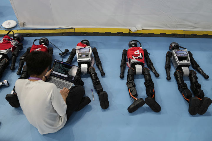 [베이징=AP/뉴시스] 15일(현지 시간) 중국 베이징 국가스피드스케이팅경기장에서 열린 2025 세계 휴머노이드 로봇 운동회에서 기술자가 로봇을 점검하고 있다. 2025.08.18.