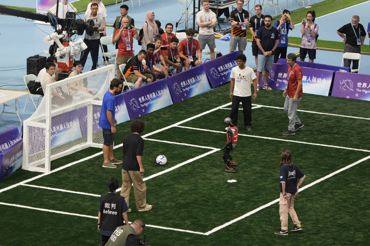 [베이징=AP/뉴시스] 17일(현지 시간) 중국 베이징 국가스피드스케이팅경기장에서 열린 2025 세계 휴머노이드 로봇 운동회에서 인간과 로봇이 축구 경기를 하고 있다. 2025.08.18.
