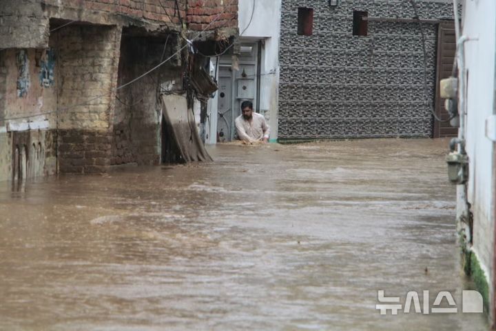[스와트(파키스탄)=AP/뉴시스]파키스탄에서 폭우가 내려 최소 344명이 사망했다고 재난 당국이 밝혔다. 사진은 피해가 집중된 스와트 지역의 주민이 침수된 거리를 헤쳐나가는 모습. 2025.08.17.
