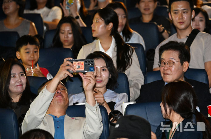 [서울=뉴시스] 최동준 기자 = 이재명 대통령과 김혜경 여사가 17일 서울 용산구 CGV에서 영화 '독립군:끝나지 않은 전쟁'을 관람 하기 위해 상영관에 입장해 시민들과 사진을 찍고 있다.   이 대통령은 광복 80주년을 기념해 SNS를 통해 함께 관람을 원하는 국민 신청을 받아 동반 관람했다. 2025.08.17. photocdj@newsis.com