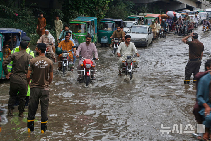 [AP/뉴시스] 18일 파키스탄 북서부 페샤와르 시내가 침수되어 경찰들이 교통 정리하고 있다