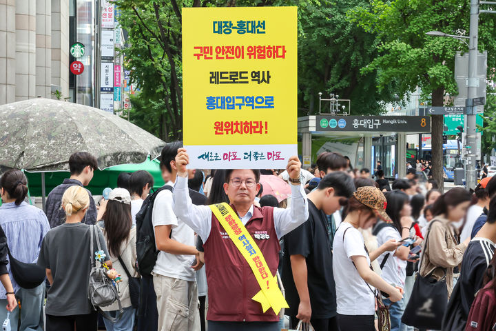 [서울=뉴시스] 17일 유동인구가 가장 많은 홍대입구역 인근에서 1인 피켓 시위를 하는 박강수 마포구청장.
