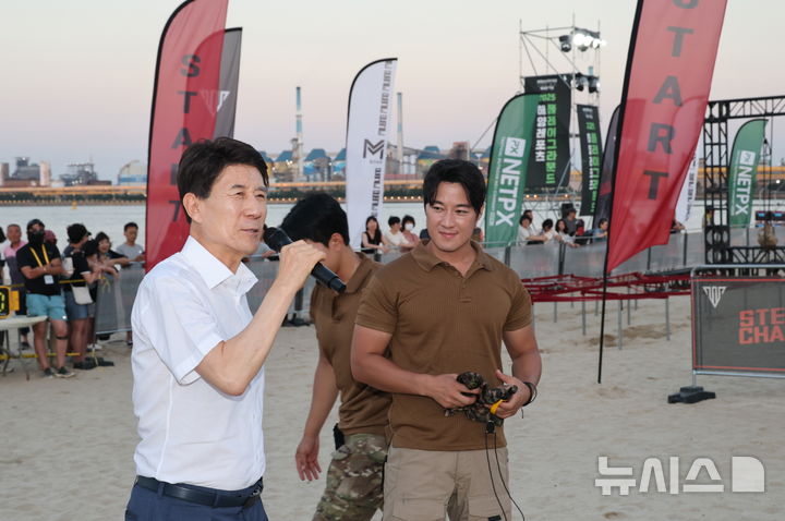 [포항=뉴시스] 송종욱 기자 = 경북 포항시는 송도해수욕장 재개장을 기념해 개최한 비치사커·강철 챌린지 '해양 레포츠 플레이 그라운드'가 성황리에 열렸다고 밝혔다. 사진은 강철 챌린지 '해양 레포츠 플레이 그라운드'가 열린 가운데 인사말을 하는 이강덕(왼쪽) 시장을 최영재 마스터가 바라보는 모습. (사진=포항시 제공) 2025.08.18. photo@newsis.com