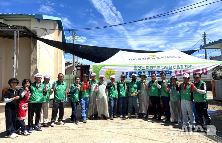 [포항=뉴시스] 송종욱 기자 = 새마을지도자포항시협의회는 지난 16일 광복 80주년을 기념해 북구 신광면 신광중학교에서 열린 축구대회·민속경기에 '1000인분 사랑의 짜장면 나눔' 봉사를 했다. 사진은 봉사를 마친 회원들이 기념 촬영하는 모습. (사진=포항시 제공) 2025.08.18. photo@newsis.com