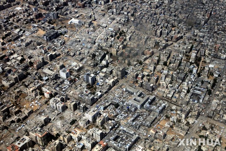 [가자지구=신화/뉴시스] 17일(현지 시간) 요르단 공군 수송기가 가자지구 상공에서 팔레스타인 주민들에게 전달한 구호물자를 공중 투하하는 가운데 가지구에서 연기가 피어오르고 있다. 이날 요르단은 약 106톤의 식량과 구호 물품을 가자지구에 투하했다. 2025.08.18.