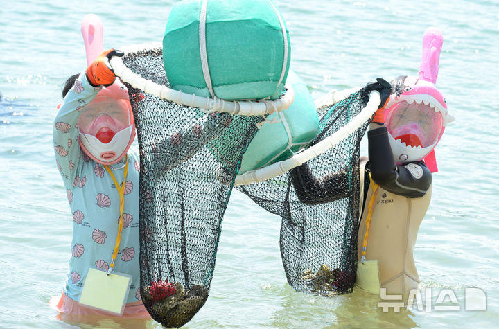 [울산=뉴시스] 배병수 기자 = 울산 동구 마을공동체 ‘진격의 해녀들’에서 주최한 '신나는 바다놀이터 용감한 꼬마해녀 체험단' 행사가 18일 오전 동구 일산해수욕장 일원에서 진행된 가운데 참가한 어린이들이 바다에서 해산물을 잡고 있다. 2025.08.18.bbs@newsis.com.