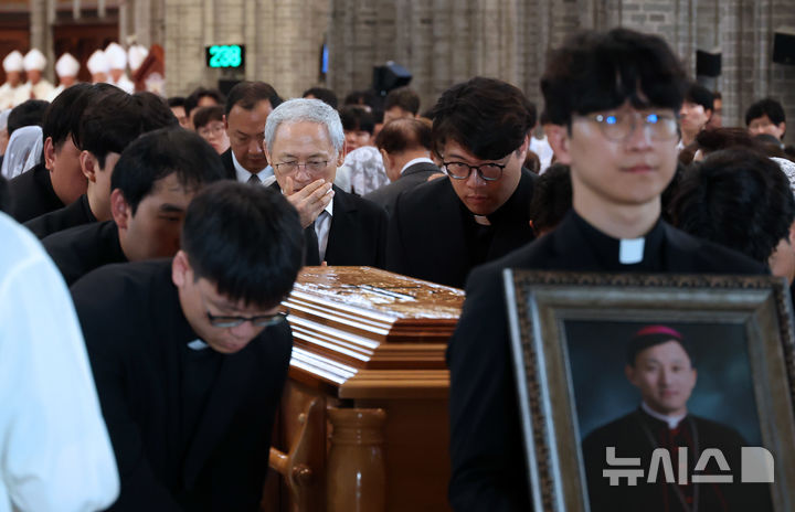 [서울=뉴시스] 사진공동취재단 = 18일 서울 중구 명동대성당에서 엄수된 천주교 서울대교구 고(故) 유경촌 주교 장례미사에서 유인촌 전 문화체육관광부 장관과 유족들이 운구 차량으로 향하고 있다. 2025.08.18. photo@newsis.com