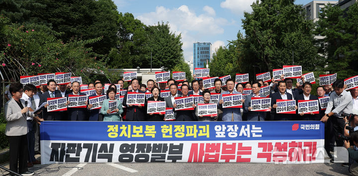 [서울=뉴시스] 김선웅 기자 = 송언석 국민의힘 비상대책위원장 겸 원내대표 등 당 지도부, 의원들이 18일 서울 서초구 서울중앙지법 앞에서 비상 의원총회를 열고 '정치보복 영장발부' 사법부를 규탄하고 있다. 2025.08.18. mangusta@newsis.com