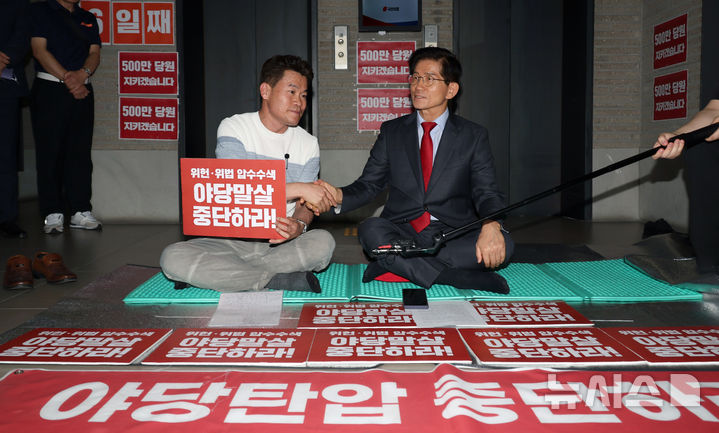 [서울=뉴시스] 김금보 기자 = 김문수 국민의힘 당대표 후보가 18일 서울 여의도 중앙당사에서 특검 압수수색 규탄 농성장을 찾은 전한길 전 한국사 강사와 악수를 하고 있다. 2025.08.18. kgb@newsis.com