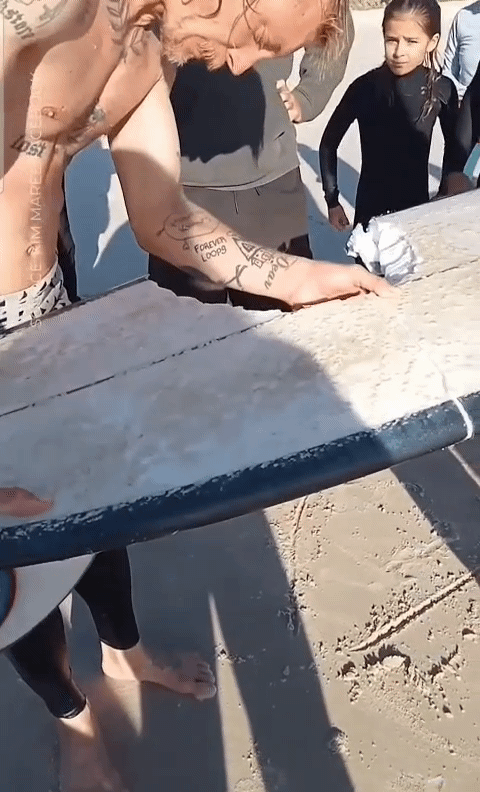 [뉴시스]호주에서 백상아리 공격을 당한 남성이 두 동강 난 서핑보드를 들어보이고 있다.(사진=인스타그램, 10뉴스) 2025.8.18 *재판매 및 DB 금지 *재판매 및 DB 금지