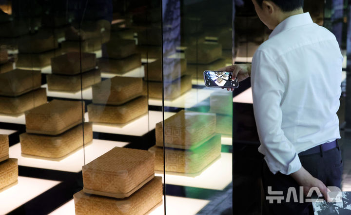 [서울=뉴시스] 홍효식 기자 = 19일 서울 중구 동대문디자인플라자(DDP)에서 열린 '헤리티지 : 더 퓨처 판타지' 전시 기자간담회에서 국가유산진흥원 직원이 국가무형유산 장인들의 실제 전승공예품을 스마트폰에 담고 있다.국내 최초 국가유산을 활용한 디지털 콘텐츠 종합 전시 '헤리티지 : 더 퓨처 판타지'는 오는 23일 개막해 9월 17일까지 열린다. 2025.08.19. yesphoto@newsis.com