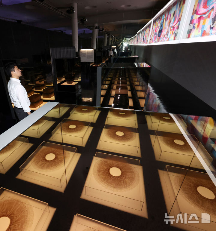 [서울=뉴시스] 홍효식 기자 = 19일 서울 중구 동대문디자인플라자(DDP)에서 열린 '헤리티지 : 더 퓨처 판타지' 전시 기자간담회에서 국가유산진흥원 직원들이 국가무형유산 장인들의 공예기술을 담은 AI 영상 '자연으로부터' 미디어아트와 실제 전승공예품을 살펴보고 있다. 국내 최초 국가유산을 활용한 디지털 콘텐츠 종합 전시 '헤리티지 : 더 퓨처 판타지'는 오는 23일 개막해 9월 17일까지 열린다. 2025.08.19. yesphoto@newsis.com