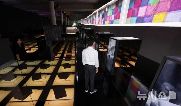 [서울=뉴시스] 홍효식 기자 = 19일 서울 중구 동대문디자인플라자(DDP)에서 열린 '헤리티지 : 더 퓨처 판타지' 전시 기자간담회에서 국가유산진흥원 직원들이 국가무형유산 장인들의 공예기술을 담은 AI 영상 '자연으로부터' 미디어아트와 실제 전승공예품을 살펴보고 있다.국내 최초 국가유산을 활용한 디지털 콘텐츠 종합 전시 '헤리티지 : 더 퓨처 판타지'는 오는 23일 개막해 9월 17일까지 열린다. 2025.08.19. yesphoto@newsis.com