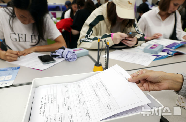  [부산=뉴시스] 하경민 기자 = '2025 외국인 유학생 채용박람회'가 열린 19일 부산 해운대구 벡스코 제2전시장에서 외국인 유학생들이 이력서를 작성하거나 구인업체 안내책자를 살펴보고 있다. 이날 행사에는 지역 제조업과 호텔·컨벤션업, 무역·물류업 등 35개 기업이 참여해 외국인 유학생 채용에 나섰다. 2025.08.19. yulnetphoto@newsis.com