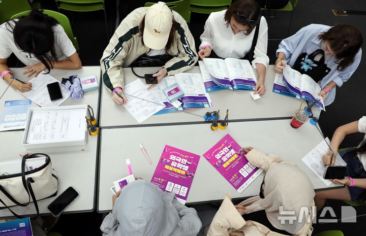  [부산=뉴시스] 하경민 기자 = '2025 외국인 유학생 채용박람회'가 열린 19일 부산 해운대구 벡스코 제2전시장에서 외국인 유학생들이 이력서를 작성하거나 구인업체 안내책자를 살펴보고 있다. 이날 행사에는 지역 제조업과 호텔·컨벤션업, 무역·물류업 등 35개 기업이 참여해 외국인 유학생 채용에 나섰다. 2025.08.19. yulnetphoto@newsis.com