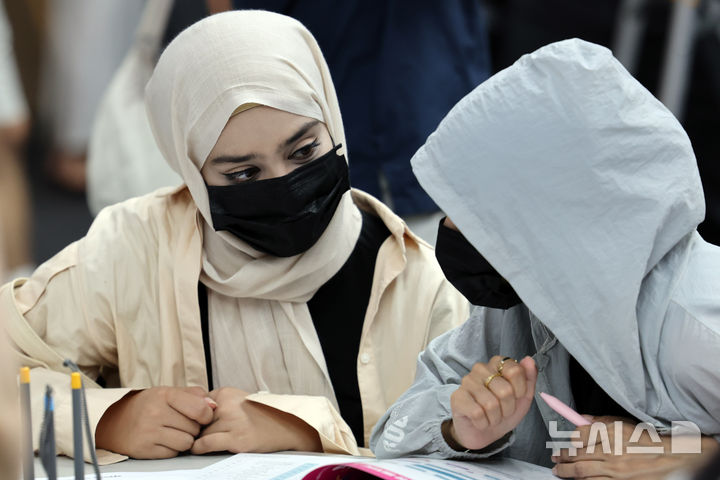  [부산=뉴시스] 하경민 기자 = '2025 외국인 유학생 채용박람회'가 열린 지난 19일 부산 해운대구 벡스코 제2전시장에서 외국인 유학생들이 이력서를 작성하거나 구인업체 안내책자를 살펴보고 있는 모습. 2025.08.19. yulnetphoto@newsis.com **기사 내용과 직접 관련 없습니다**