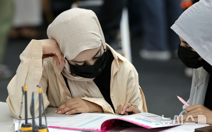  [부산=뉴시스] 하경민 기자 = '2025 외국인 유학생 채용박람회'가 열린 19일 부산 해운대구 벡스코 제2전시장에서 외국인 유학생들이 이력서를 작성하거나 구인업체 안내책자를 살펴보고 있다. 이날 행사에는 지역 제조업과 호텔·컨벤션업, 무역·물류업 등 35개 기업이 참여해 외국인 유학생 채용에 나섰다. 2025.08.19. yulnetphoto@newsis.com