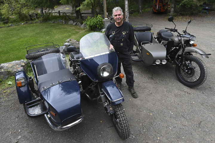 [앵커리지( 미 알래스카주)=AP/뉴시스] 트럼프-푸틴 정상회담 덕에 러시아제 오토바이를 얻은 알래스카 주민 마크 워런이 8월18일 앵커리지에서 러시아 정부가 보내 준 최신형 러시아산 우랄 오토바이 옆에 서 있다. 뒤쪽은 그가 오래 타던 낡은 우랄 오토바이. 2025.08.22. 