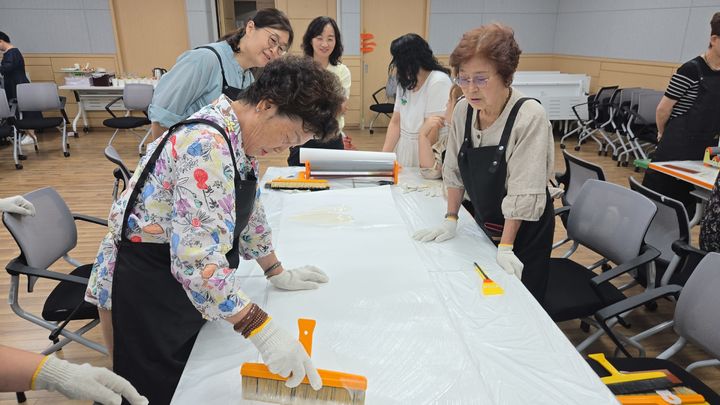 [부산=뉴시스] 보수동 집수리(도배) 교육 모습. (사진=부산도시공사 제공) 2025.08.20. photo@newsis.com *재판매 및 DB 금지