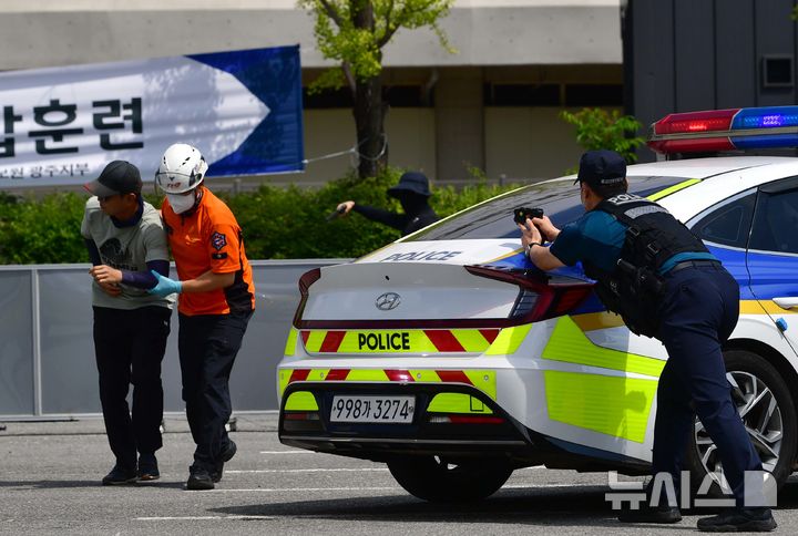 [광주=뉴시스] 이현행 기자 = 20일 오전 광주 서구 월드컵경기장 일대에서 펼쳐진 2025 을지연습 세계양궁선수권 대회 대테러 훈련 도중 구급대원이 경찰 엄호 속에 부상당한 시민을 부축하고 있다. 2025.08.20. lhh@newsis.com